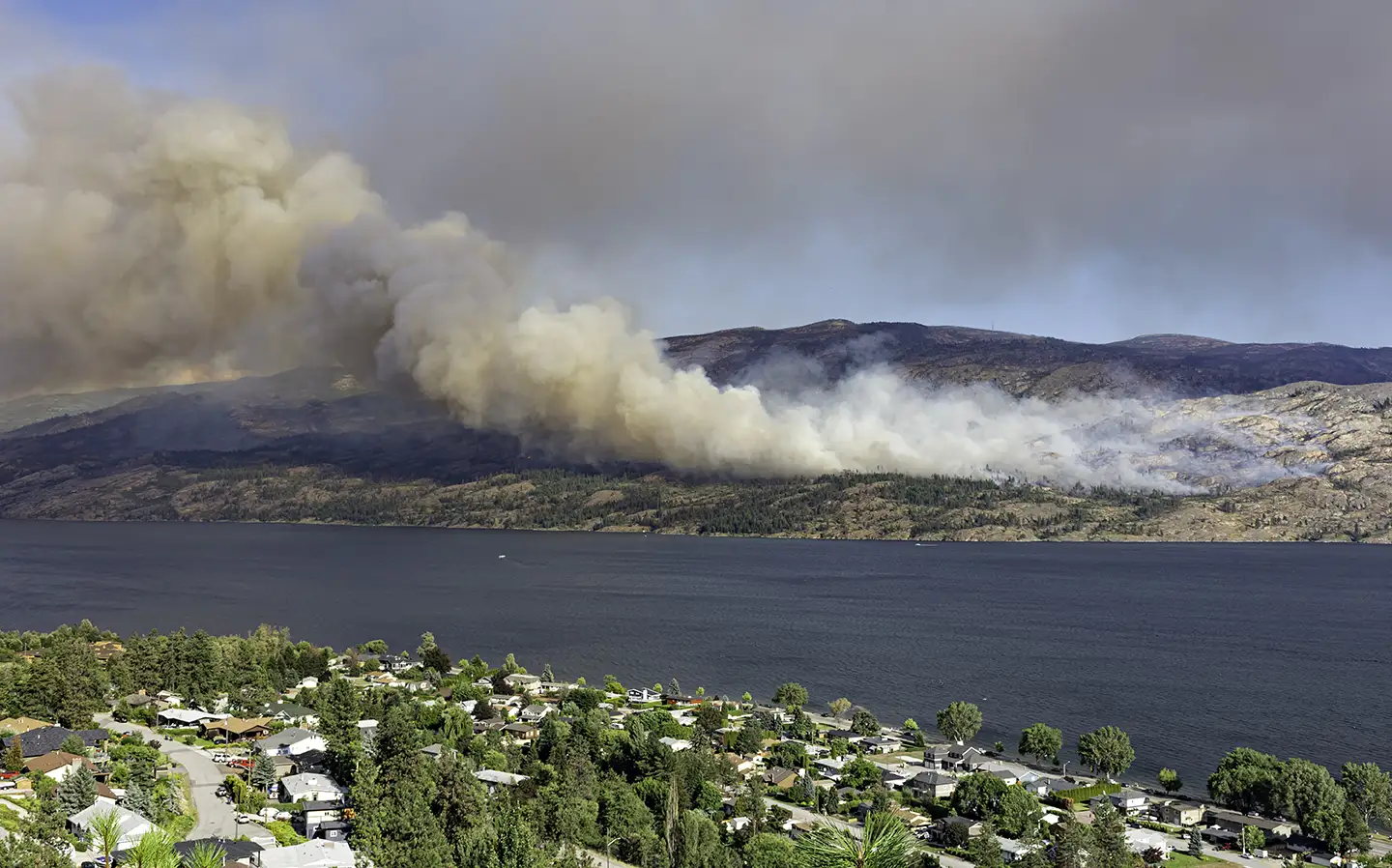 Aerial photo of wildfire spreading from across a lake